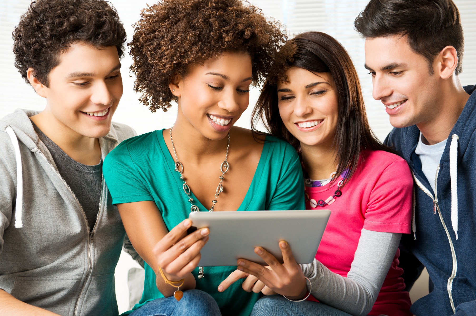 4_young_people_sharing_white_tablet